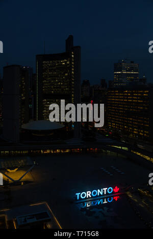 An aerial night time view across Nathan Phillips Square in Toronto, Canada.  The illuminated 3D Toronto sign can be seen. Stock Photo