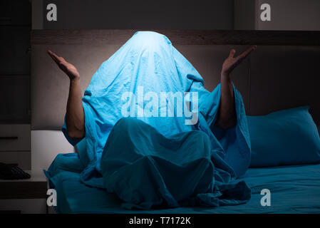 Young man scared in his bed having nightmares Stock Photo