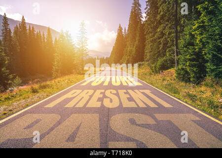 Past, Present, Future concept. Driving on an empty road in the mountains to the Future passing Present and leaving behind the Past. Stock Photo