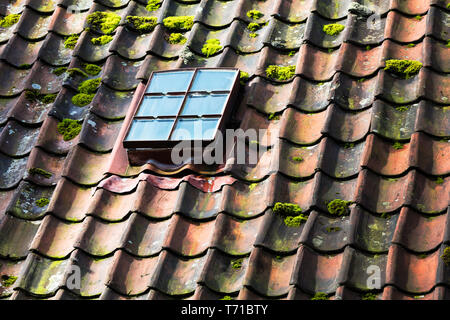 skylight on old ceramic tiles house roof Stock Photo