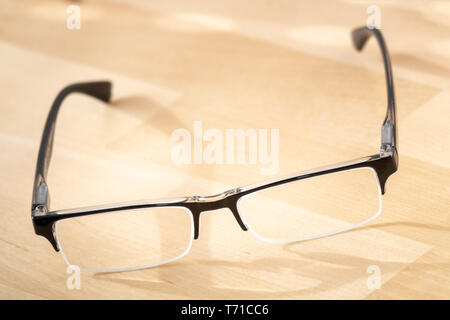 reading glasses on a wooden table Stock Photo
