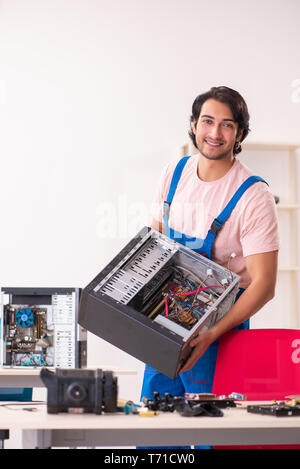 Young male contractor repairing computer Stock Photo