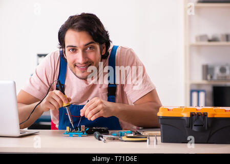 Young male contractor repairing computer Stock Photo