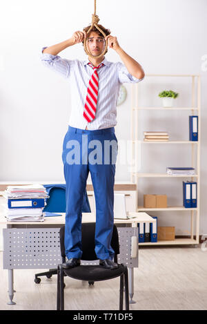 Desperate businessman thinking of committing suicide hanging Stock Photo