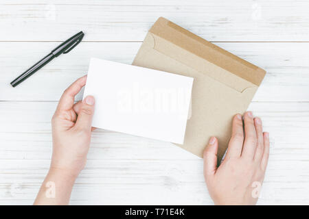 Hand hold a envelope and paper on the wooden background Stock Photo