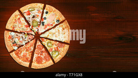 mix of eight different pizzas on a wooden background. menu concept of choice and diversity Stock Photo