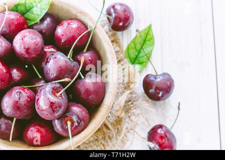 Fresh cherries in bowl on wooden table Stock Photo
