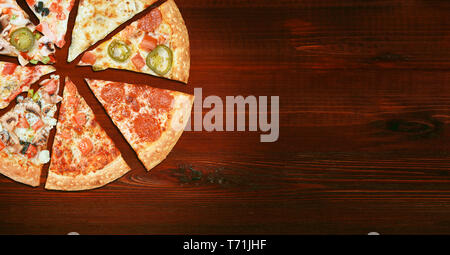 mix of eight different pizzas on a wooden background. menu concept of choice and diversity Stock Photo