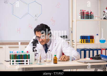 Young funny chemist in front of white board Stock Photo