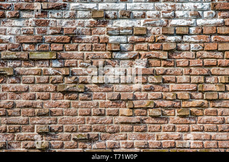Old masonry wall with chalk and other impurities and with protruding bricks forming an irregular relief pattern Stock Photo