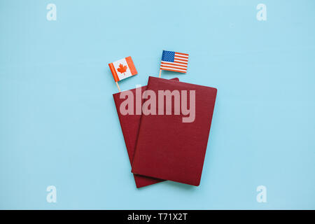 Foreign passport with the flags of the USA and Canada on a blue background. The concept of migration, work and travel. Stock Photo