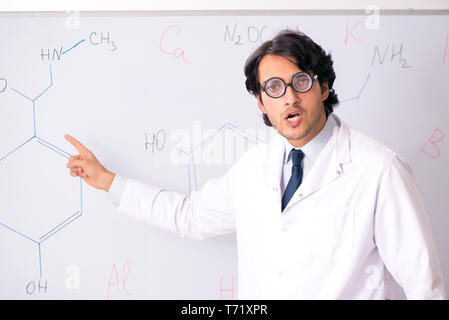 Young funny chemist in front of white board Stock Photo