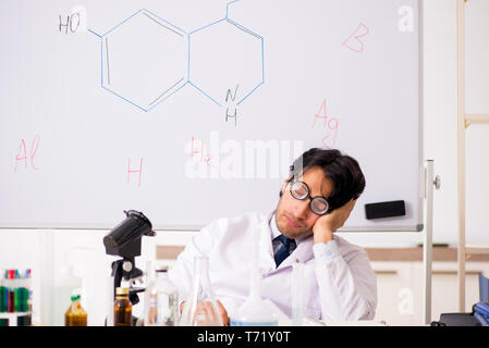 Young funny chemist in front of white board Stock Photo