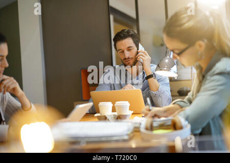 Young attractive colleagues in co working space Stock Photo