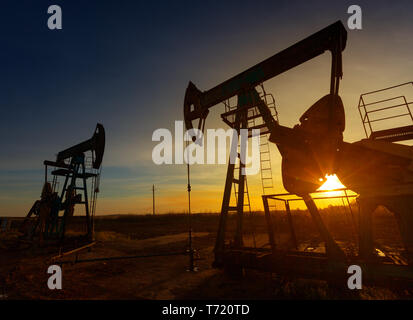 Two working oil pumps silhouette Stock Photo