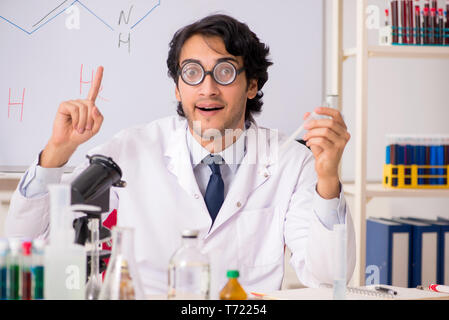 Young funny chemist in front of white board Stock Photo
