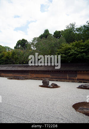 A view of the rock islands, gravel seas and boundary walls of the Japanese Zen Garden at Ryoan-Ji Temple in Kyoto. Stock Photo