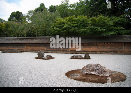 A view of the rock islands, gravel seas and boundary walls of the Japanese Zen Garden at Ryoan-Ji Temple in Kyoto. Stock Photo