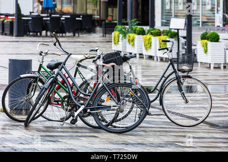 bikes parked on street in rainy weather Stock Photo