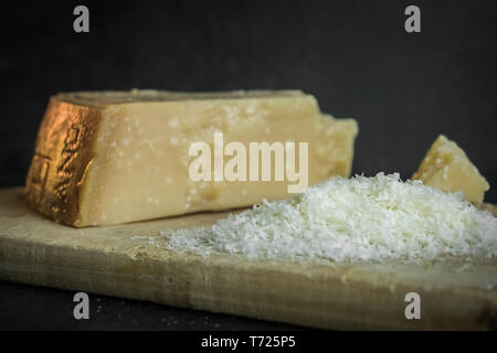 Grated parmesan cheese on black background, italian food. Dark food Stock Photo