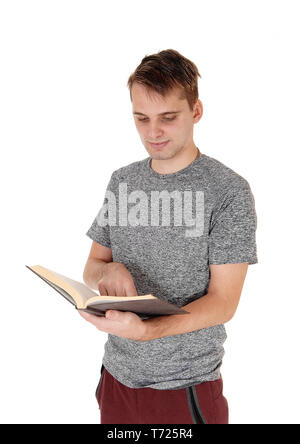 Young man standing reading his book Stock Photo