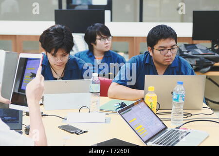 Groups of Computer Engineering students at Assumption University (ABAC) Working on their coding project in a classroom Stock Photo
