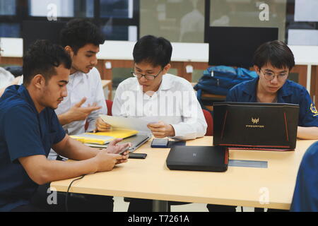 Groups of Computer Engineering students at Assumption University (ABAC) Working on their coding project in a classroom Stock Photo