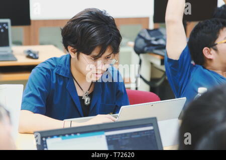 Portrait of a Computer Engineering student at Assumption University working on his coding project on his laptop Stock Photo