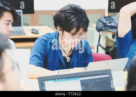 Portrait of a Computer Engineering student at Assumption University working on his coding project on his laptop Stock Photo