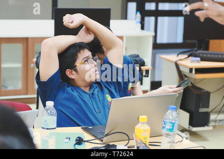 Portrait of a Computer Engineering student at Assumption University stretching after working on his computer programming project Stock Photo