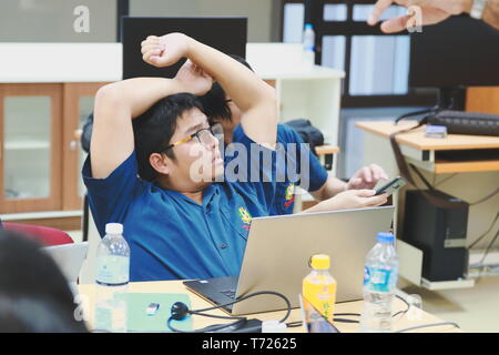 Portrait of a Computer Engineering student at Assumption University stretching after working on his computer programming project Stock Photo