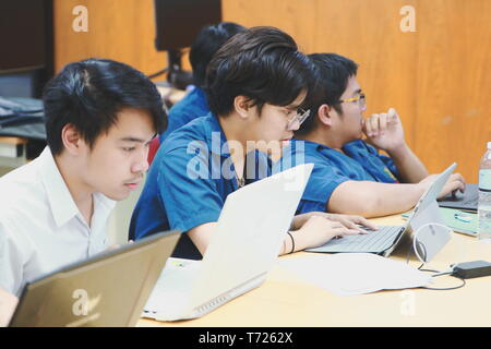 Groups of Thai Computer Engineering students at Assumption University (ABAC) Working on their coding project in a classroom Stock Photo
