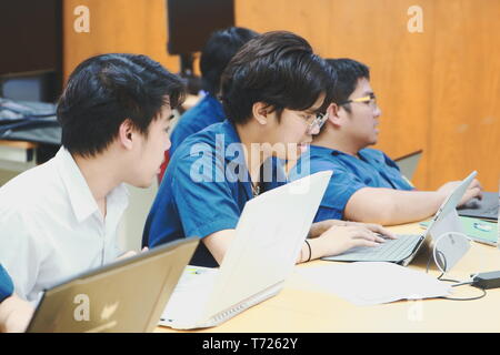 Groups of Thai Computer Engineering students at Assumption University (ABAC) Working on their coding project in a classroom Stock Photo
