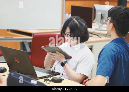 Chinese Computer Engineering Student taking lecture note on his iPad using Apple Pencil during a computer programming class Stock Photo