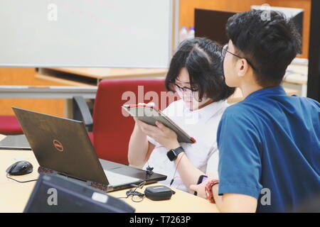 Chinese Computer Engineering Student taking lecture note on his iPad using Apple Pencil during a computer programming class Stock Photo