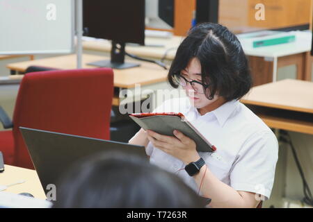 Chinese Computer Engineering Student taking lecture note on his iPad using Apple Pencil during a computer programming class Stock Photo