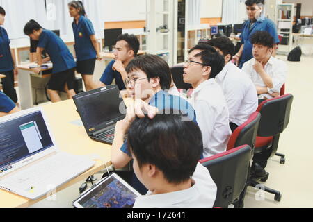 Groups of Thai Computer Engineering students at Assumption University (ABAC) Working on their coding project in a classroom Stock Photo