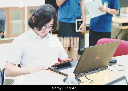 Chinese Computer Engineering Student taking lecture note on his iPad using Apple Pencil during a computer programming class Stock Photo