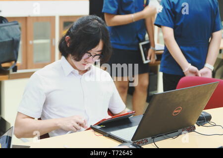 Chinese Computer Engineering Student taking lecture note on his iPad using Apple Pencil during a computer programming class Stock Photo