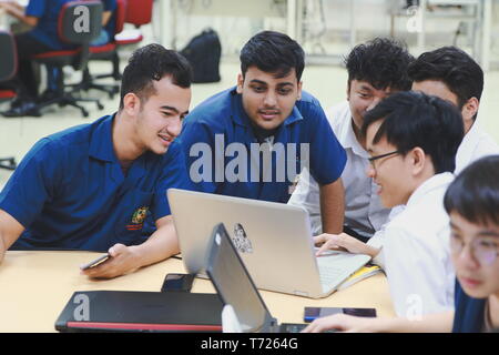 Group of Asian computer engineering students working together to complete a computer programming project at an University Stock Photo