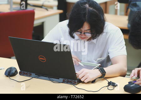 Chinese Computer Engineering Student taking lecture note on his iPad using Apple Pencil during a class Stock Photo