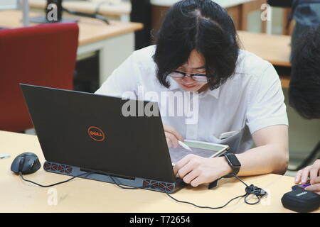 Chinese Computer Engineering Student taking lecture note on his iPad using Apple Pencil during a class Stock Photo