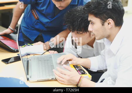 Group of Asian computer engineering students working together to complete a computer programming project at an University Stock Photo