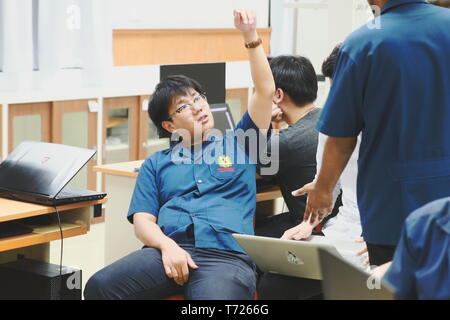 Two Thai Computer engineering student discussing about their project in the computer class Stock Photo