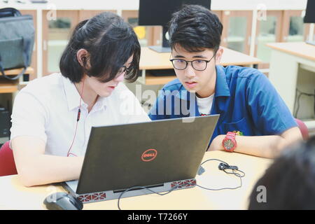 Portrait of a Computer Engineering student at Assumption University working on his coding project on his laptop Stock Photo
