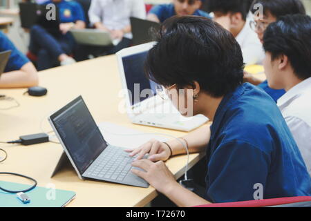 Portrait of a Computer Engineering student at Assumption University working on his coding project on his laptop Stock Photo