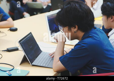 Portrait of a Computer Engineering student at Assumption University working on his coding project on his laptop Stock Photo