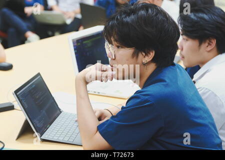Portrait of a Computer Engineering student at Assumption University working on his coding project on his laptop Stock Photo