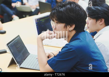 Portrait of a Computer Engineering student at Assumption University working on his coding project on his laptop Stock Photo