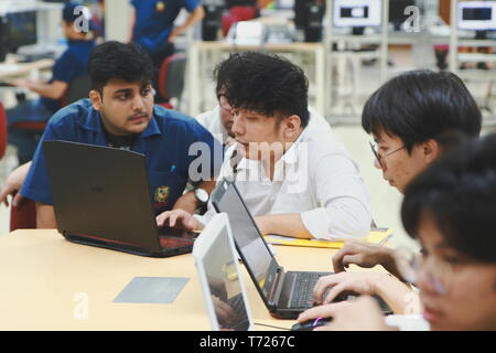 Group of Asian computer engineering students working together to complete a computer programming project at an University Stock Photo